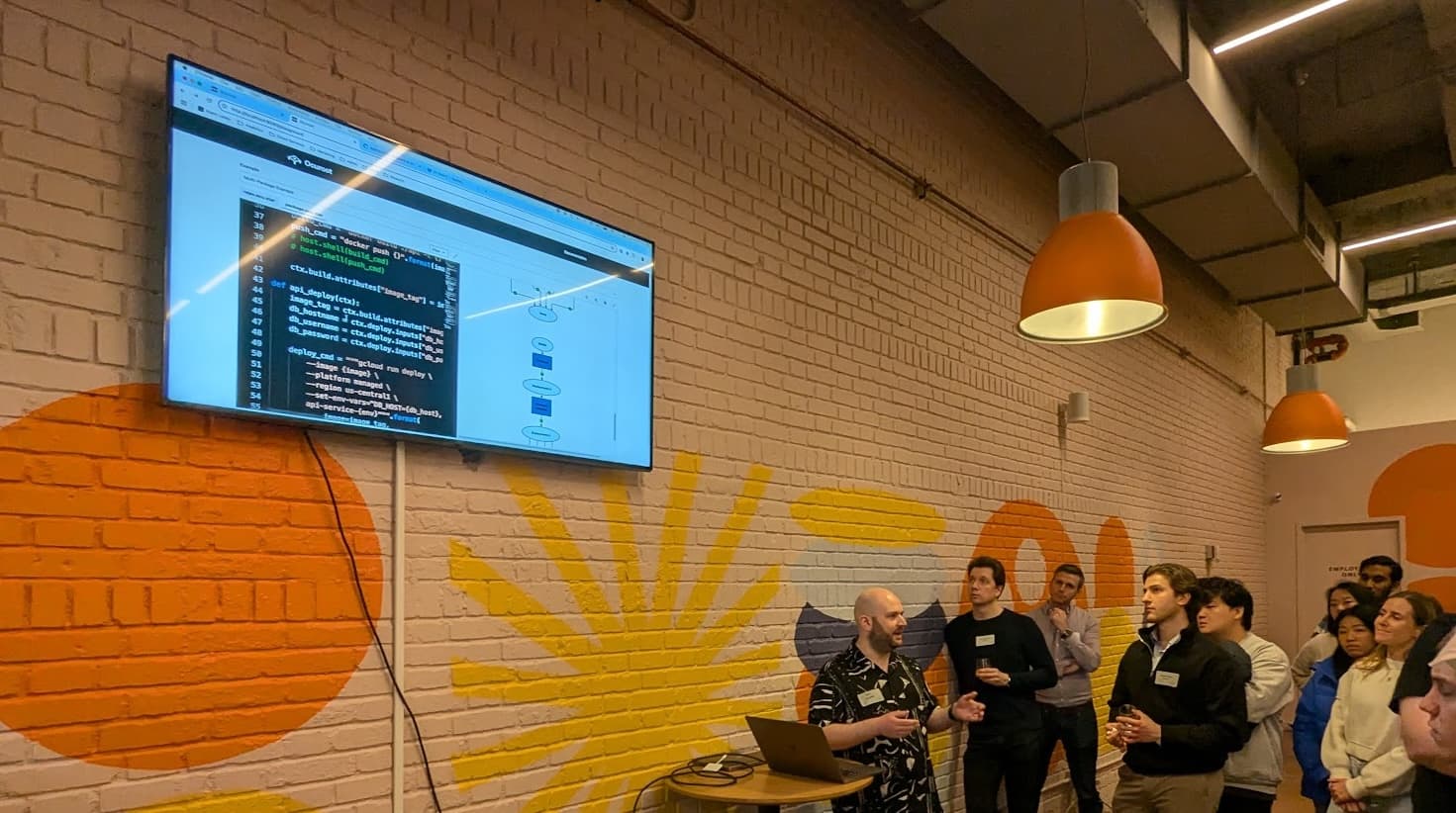 Tom presenting at a meetup, showing a pipeline configuration and its underlying code.