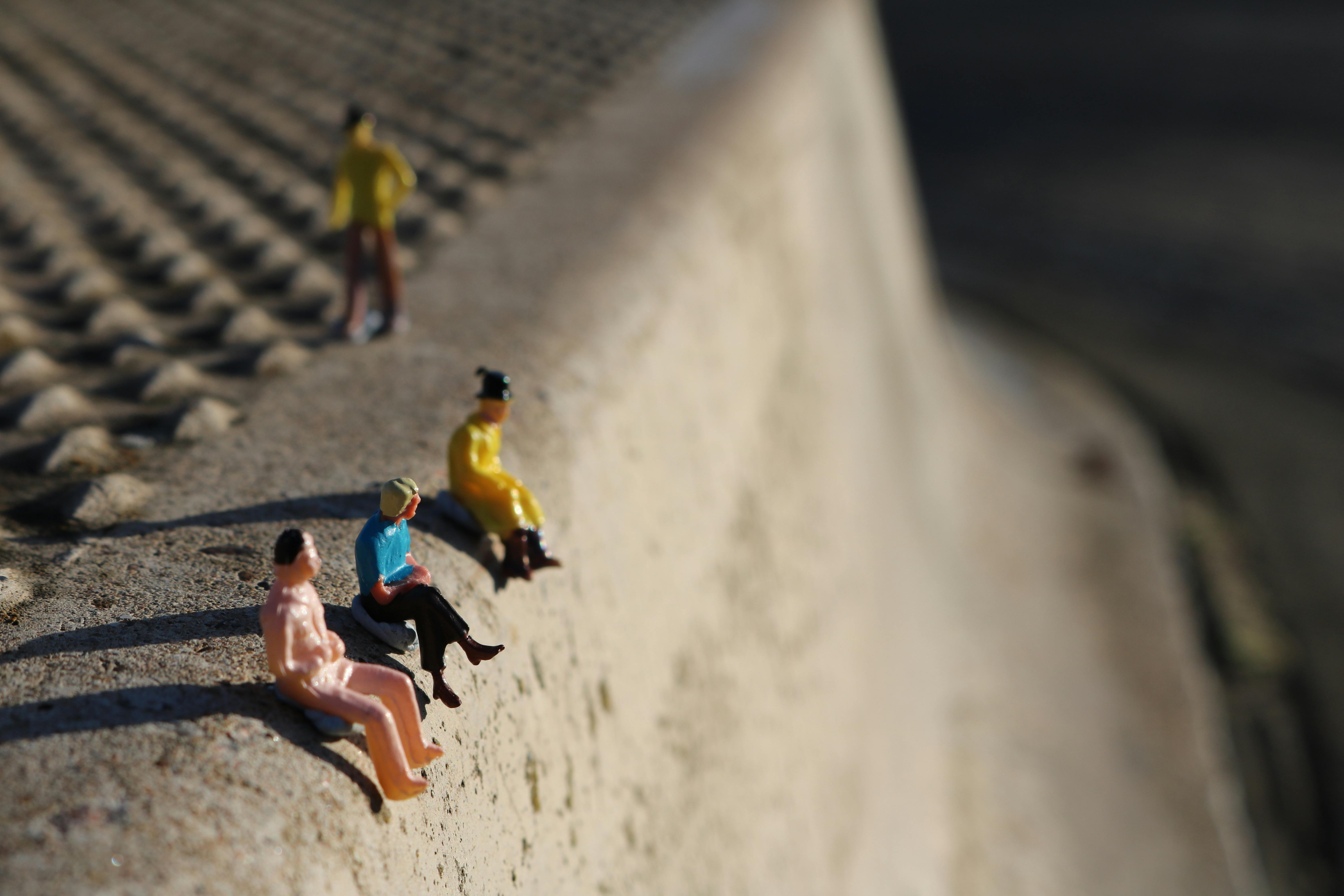 Miniatures of people sitting on a kerb.